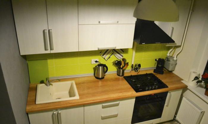 La combinazione di grigio e bianco in cucina con un piano di lavoro in legno