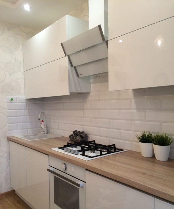 Elettrodomestici bianchi in una cucina bianca con piano di lavoro in legno