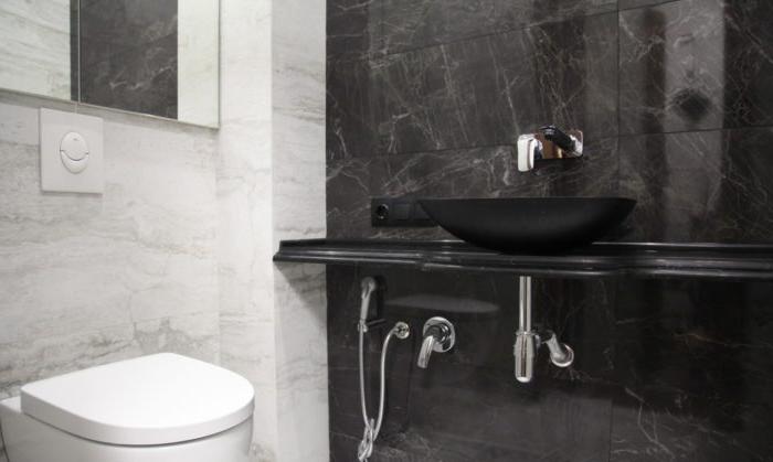 La combinazione di piastrelle scure e chiare per il bagno