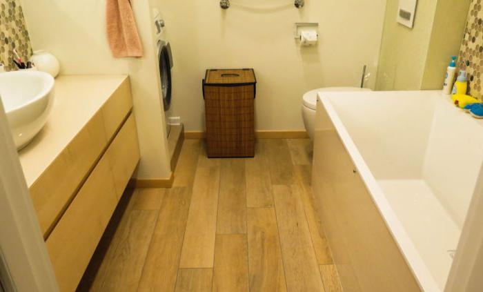 Mattonelle di legno del Brown sul pavimento del bagno