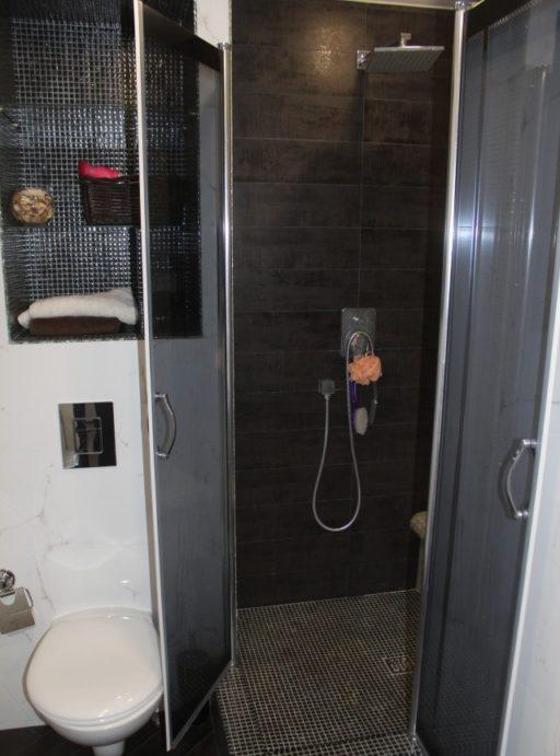 Piastrelle e mosaici neri nella doccia e nella toilette