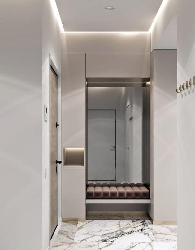 Ingresso bianco in un appartamento in stile moderno con piastrelle in marmo