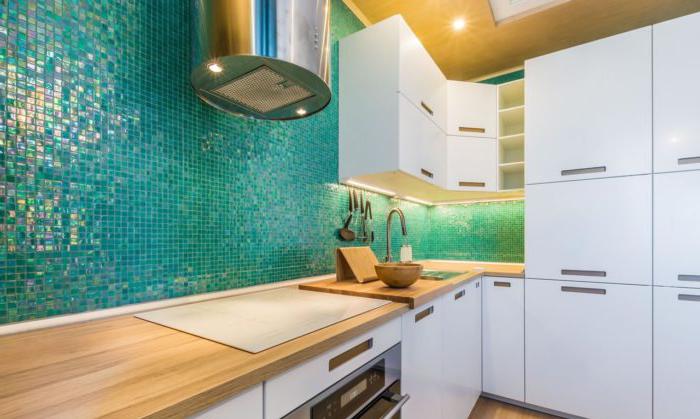 Interno bianco della cucina con piano di lavoro in legno e grembiule in mosaico verde