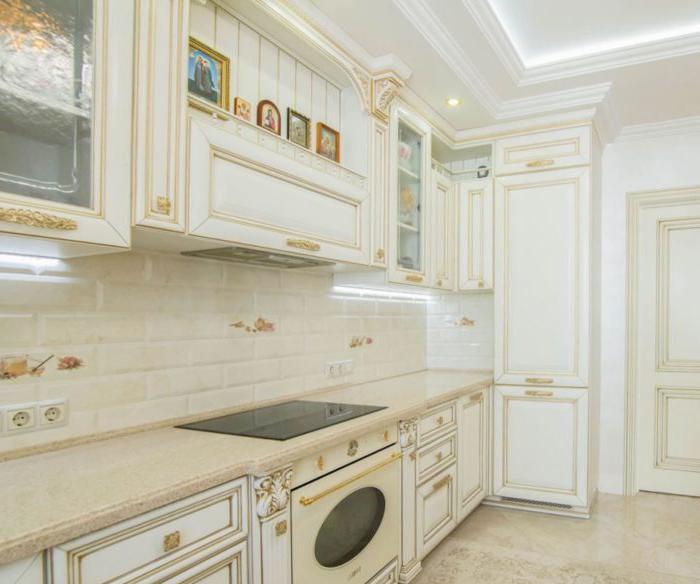 solida cucina classica bianca e oro con un portale